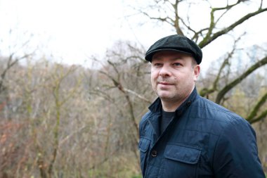 Adam sonbahar parkında dinleniyor.