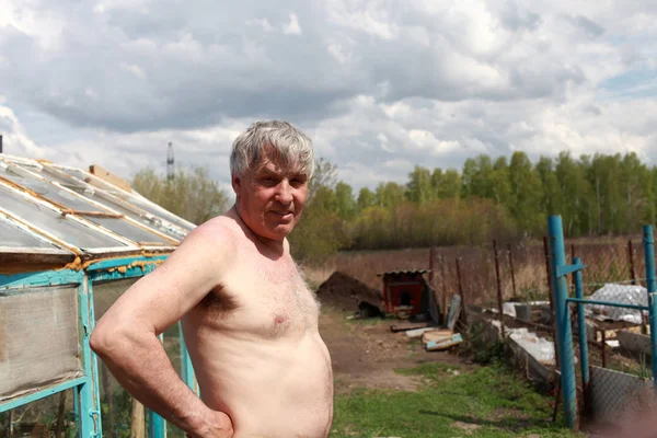 Starší muž stojí ve své zahradě — Stock fotografie
