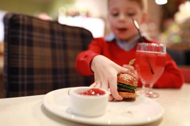 Çocuk mini burger yer.