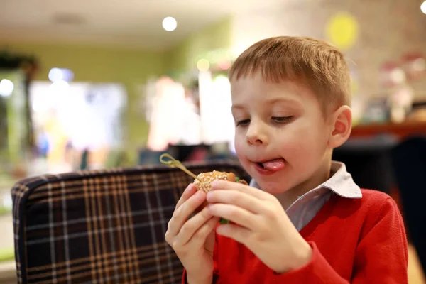 Jongen die mini hamburger eet — Stockfoto