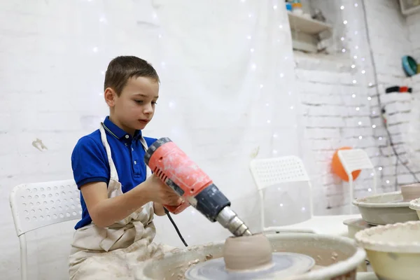 Boy drying cup on pottery wheel — Stock Photo, Image