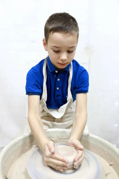 Мальчик, работающий за гончарным колесом — стоковое фото