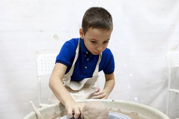 Niño en la rueda de cerámica —  Fotos de Stock