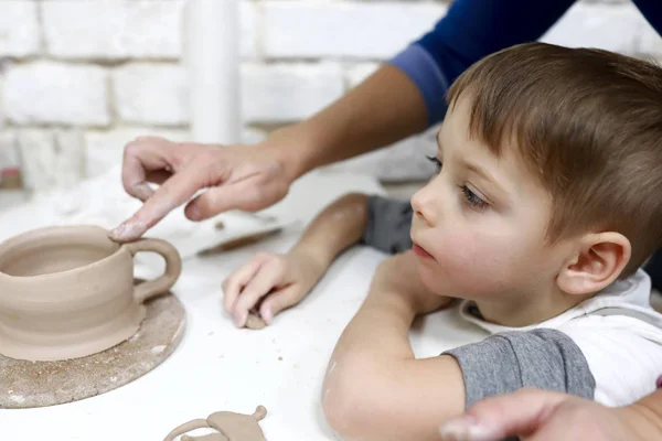 Boy sculpts clay mug — Stock Photo, Image