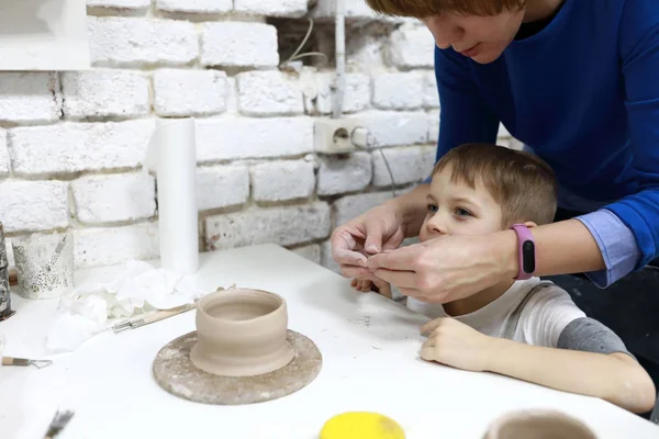 Mère avec fils sculpter tasse en argile — Photo