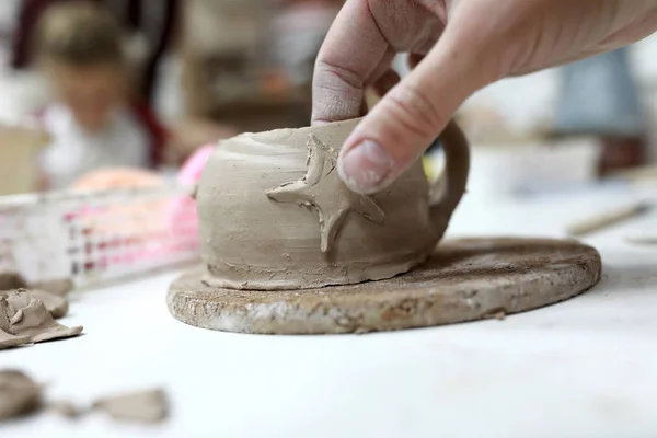 Person decorating clay mug — Stock Photo, Image