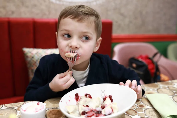 Pojke äter körsbär dumplings — Stockfoto