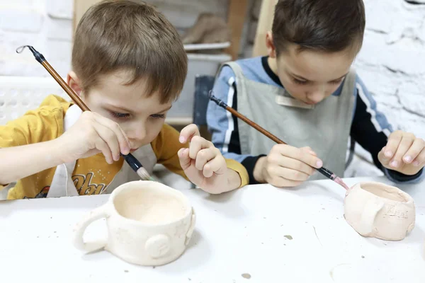 Jongens schilderen potten van klei — Stockfoto