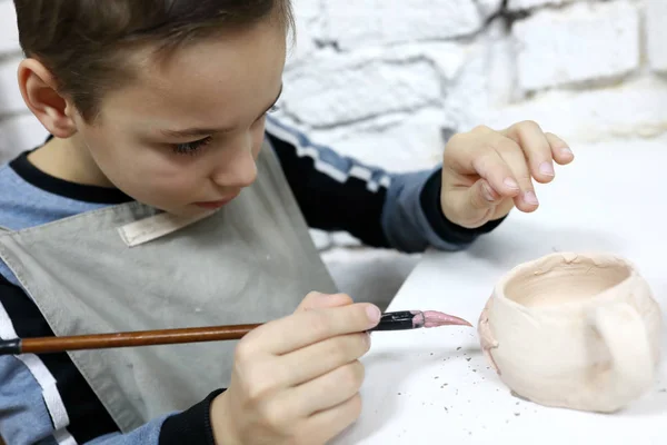 Child painting clay pot — Stock Photo, Image