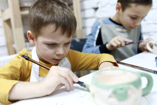 Children paint clay mugs — Stock Photo, Image