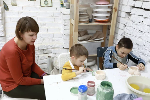 Aile kil kapları boyuyor. — Stok fotoğraf