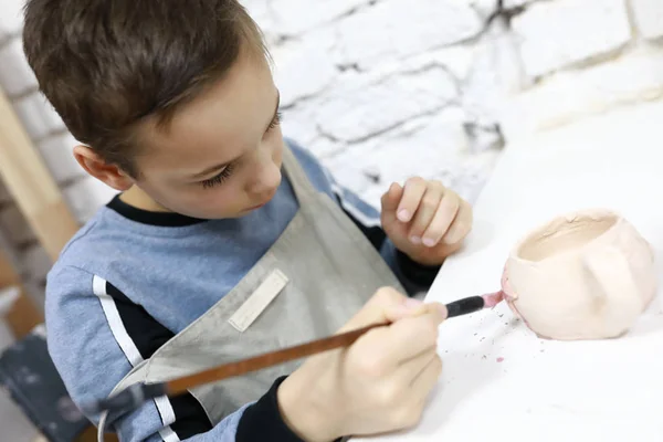 Niño pintando olla de arcilla — Foto de Stock