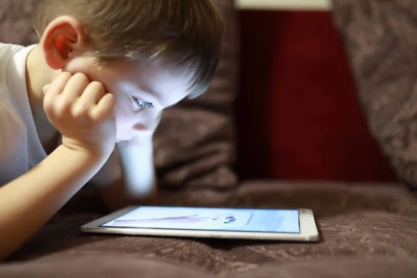 Child with tablet on sofa — Stock Photo, Image