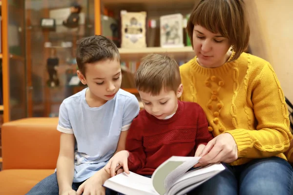 Мать с сыновьями читает книгу — стоковое фото