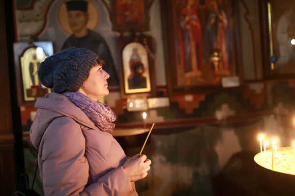 Woman with candle in church — Stock Photo, Image