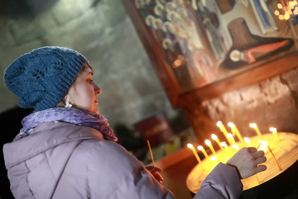 Woman holding candle in church — Stock Photo, Image