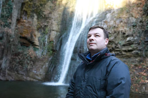 Man poseren op de achtergrond van waterval — Stockfoto