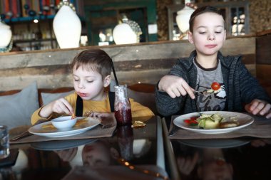 İki kardeş bir restoranda yemek yiyor.