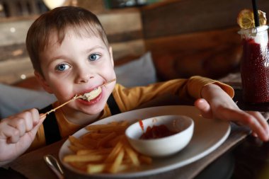 Çocuğun lokantada et kebabı var.