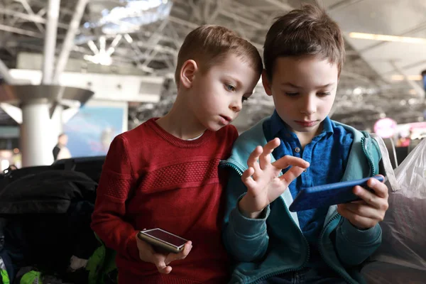 Dva Kluci Hrají Smartphony Letišti — Stock fotografie
