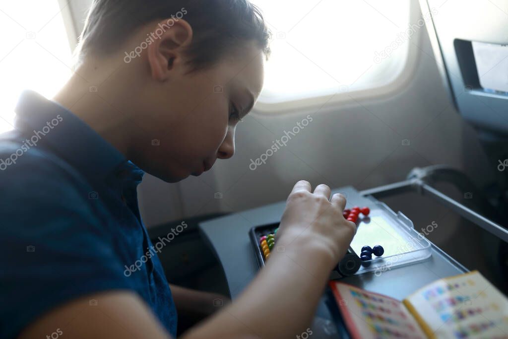 Child playing puzzle in a passenger plane