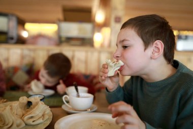 Gürcü restoranında Khinkali yiyen bir çocuk.