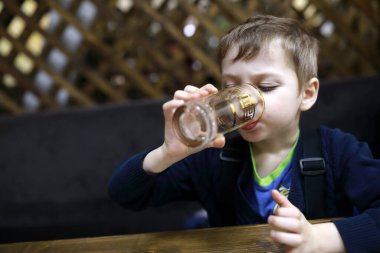 Restorandaki masada su içen çocuk.