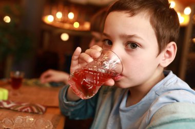 Restoranda amber çayı içen bir çocuk.