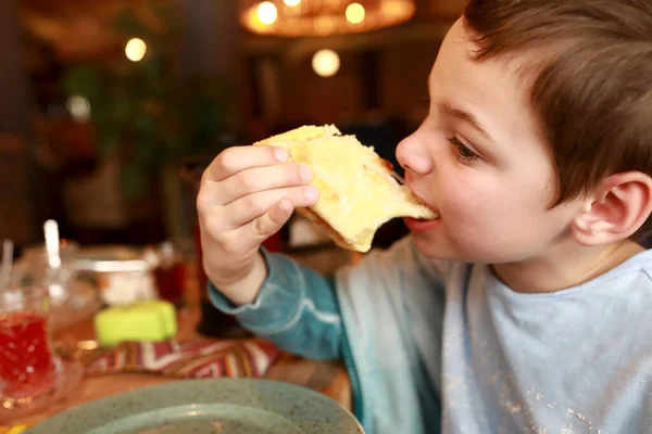 グルジア料理店でメグレリアン カチャプリを食べる子供 — ストック写真