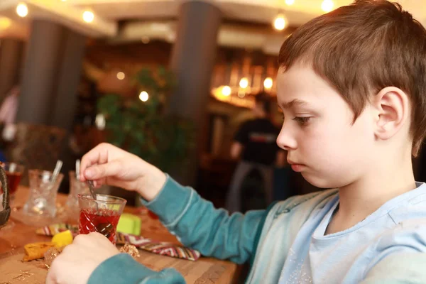 孩子们在餐馆里喝茶时搅拌糖 — 图库照片