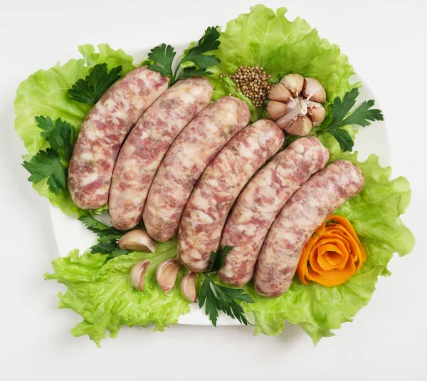 Raw sausages with salad — Stock Photo, Image