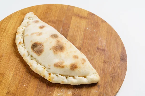 Пицца Calzone на борту — стоковое фото