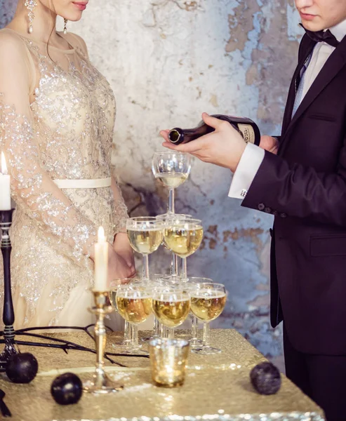 Couple by champagne glasses tower