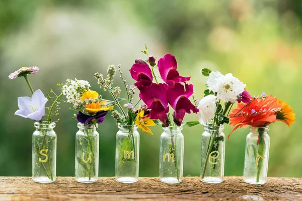 Bonitas flores en botellas — Foto de Stock