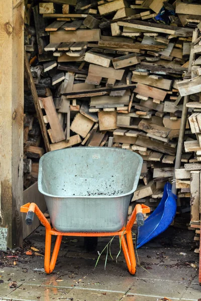 Wood logs with wheelbarrow outdoor — Stock Photo, Image