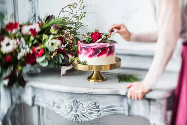 Woman decorates wedding cake — Stock Photo, Image