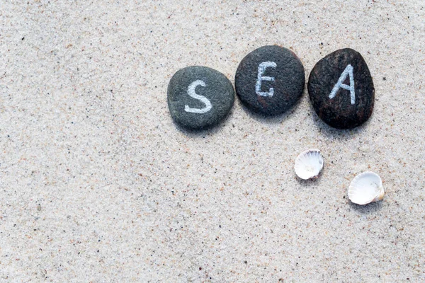 Stones with lettering on sand — Stock Photo, Image