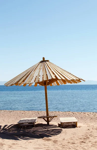 Houten parasol op het strand — Stockfoto