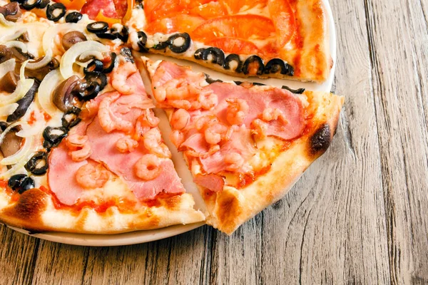 Chutné pizzy na dřevěný stůl — Stock fotografie
