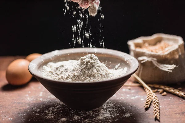 Pouring flour in black bowl — Stock Photo, Image