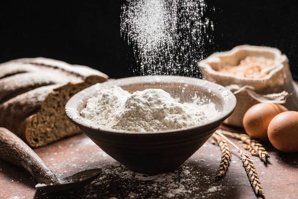 Pouring flour in black bowl — Stock Photo, Image