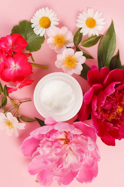 Crema cosmética con flores rosadas — Foto de Stock