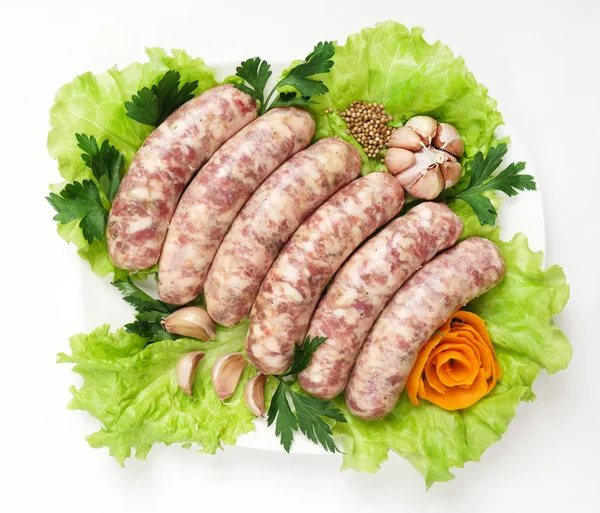 Raw sausages on leaves — Stock Photo, Image