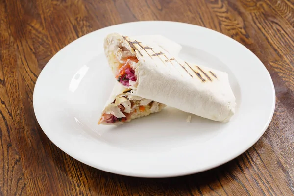 Tortilla jest zawijany na białym talerzu — Zdjęcie stockowe