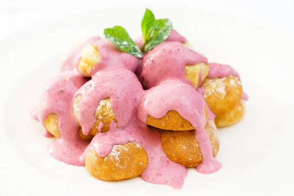 Profiteroles med rosa grädde — Stockfoto