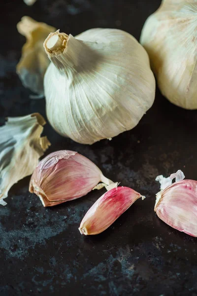 Fresh garlic on dark table — Stock Photo, Image