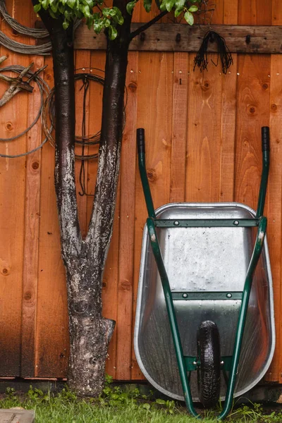 Gardening tools by fence — Stock Photo, Image