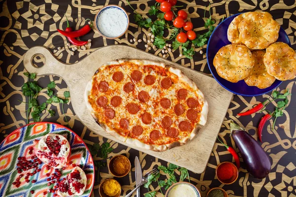 Pizza con salami sobre tabla de madera — Foto de Stock