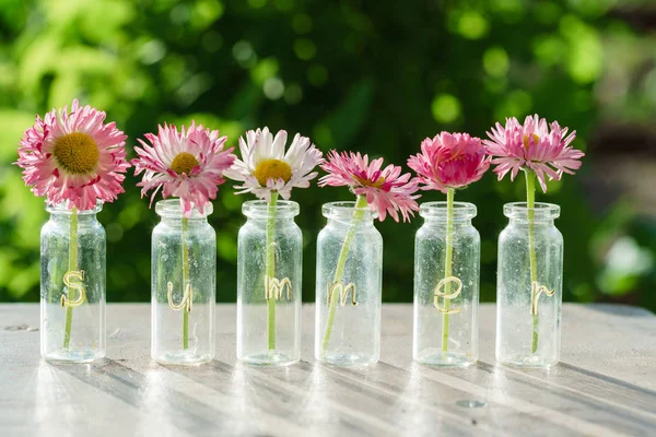Garrafas de vidro com flores — Fotografia de Stock