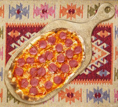 Tahtada salamlı pizza.